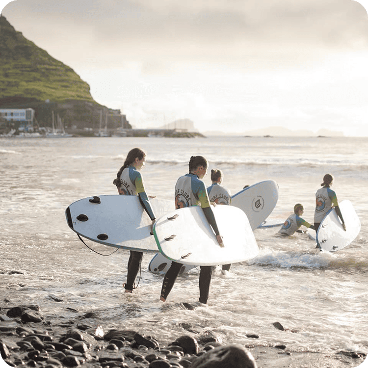 beginner surfers entering water madeira